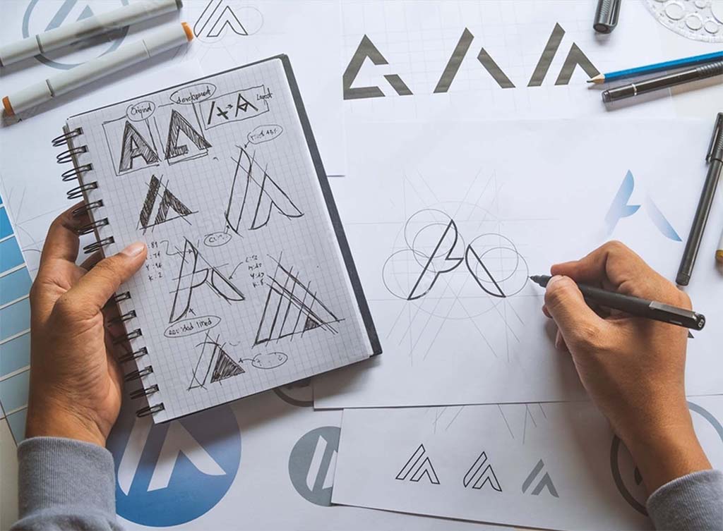 someone attempting to design a logo on paper